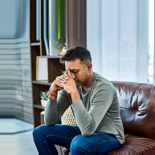 Man Holding His Head in his Hands